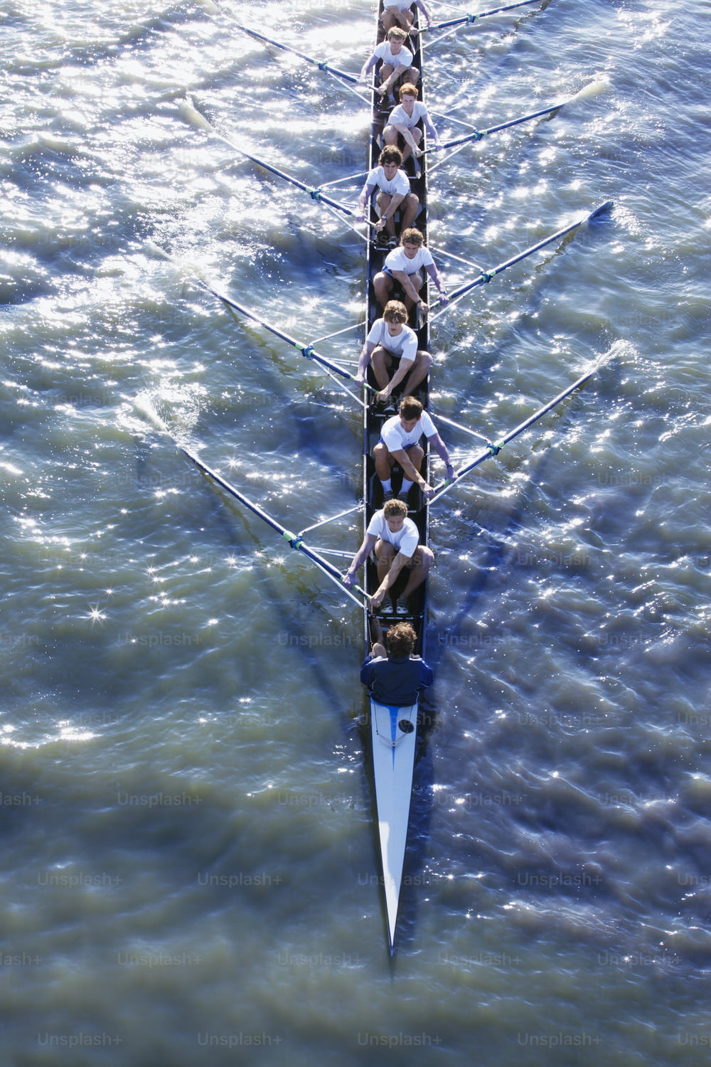 un gruppo di persone che remano una lunga barca nell'acqua
