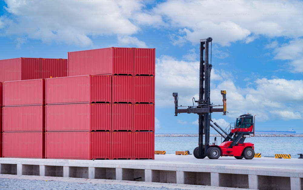 Forklift truck is lifting cargo containers at a seaport waiting for distribution terminal goods to aboard are import and export logistic transportation shipment business concept.