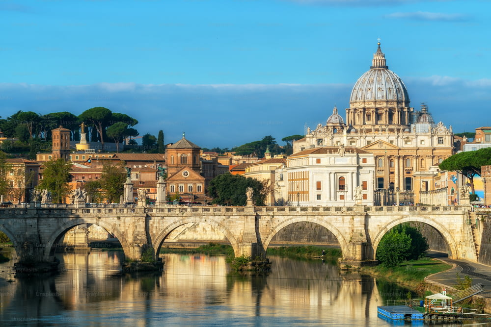 O horizonte de Roma com a Basílica de São Pedro do Vaticano e a Ponte de Santo Ângelo cruzando o rio Tibre no centro da cidade de Roma, Itália. É um marco histórico da Roma Antiga e destino de viagem.