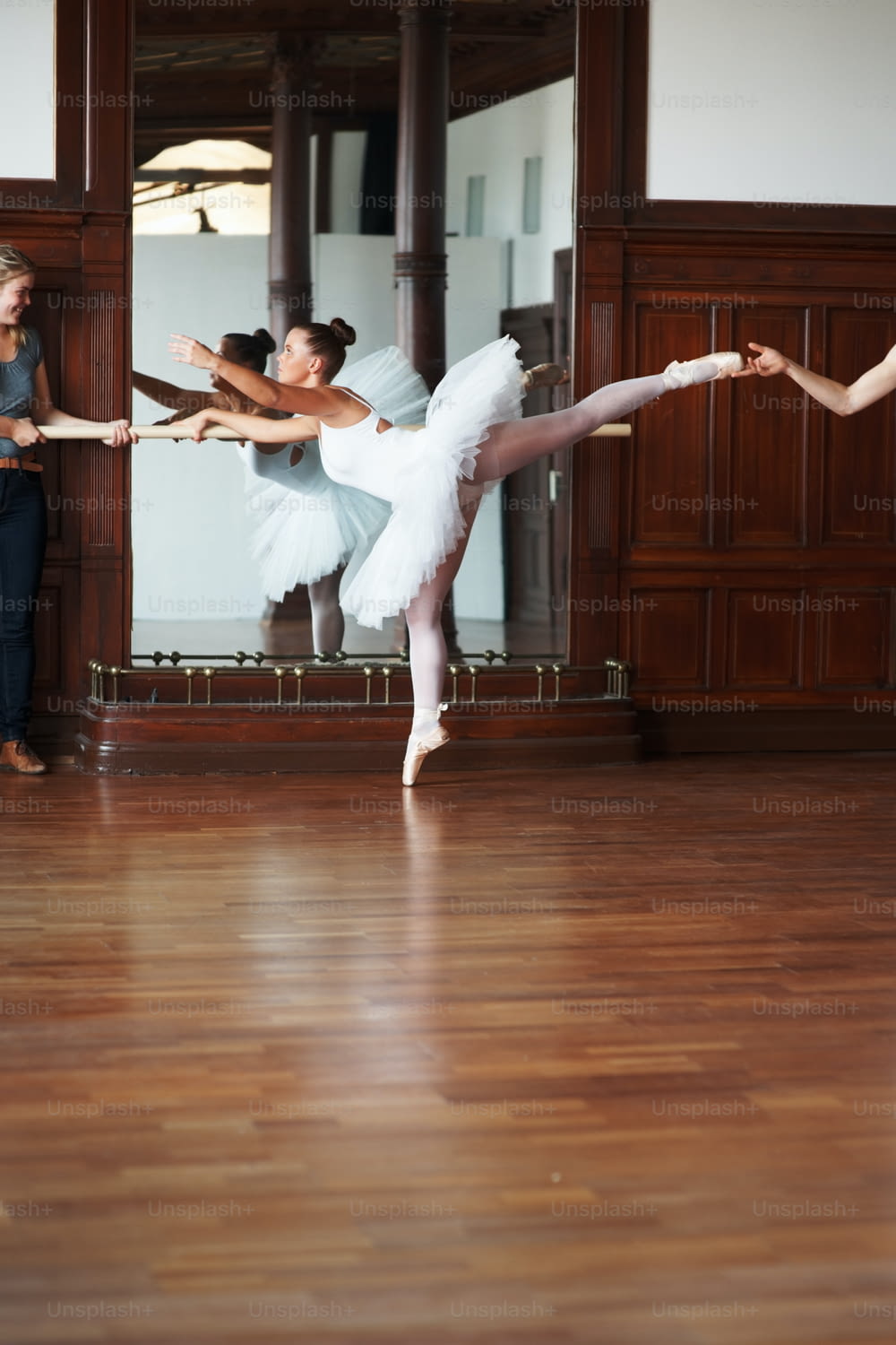 two ballerinas in a dance studio with a mirror in the background