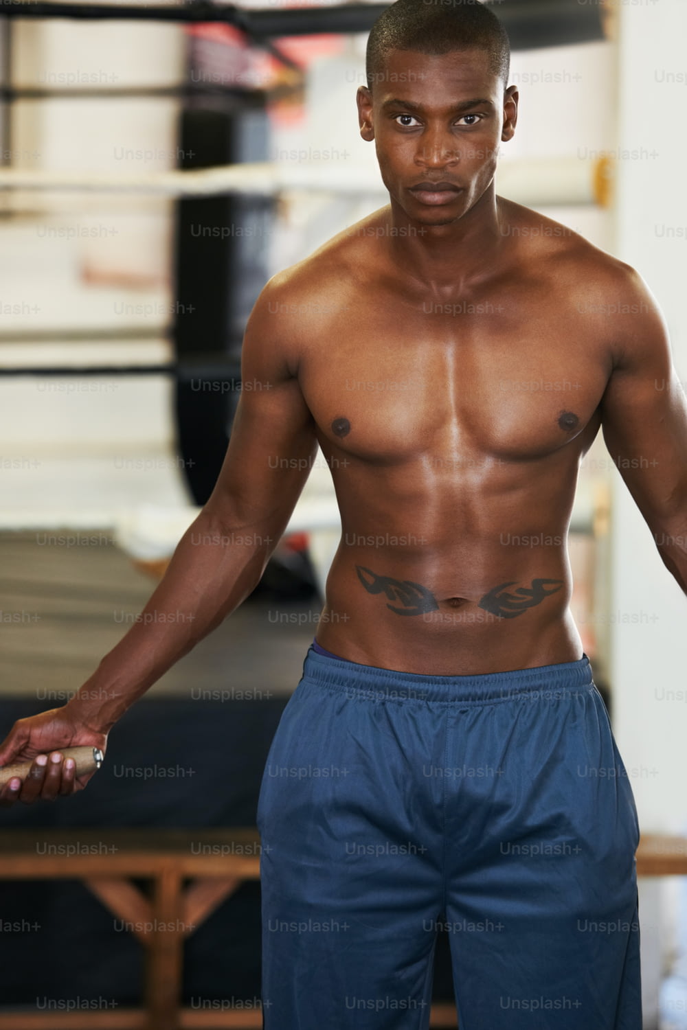 Un hombre sin camisa parado en un ring de boxeo