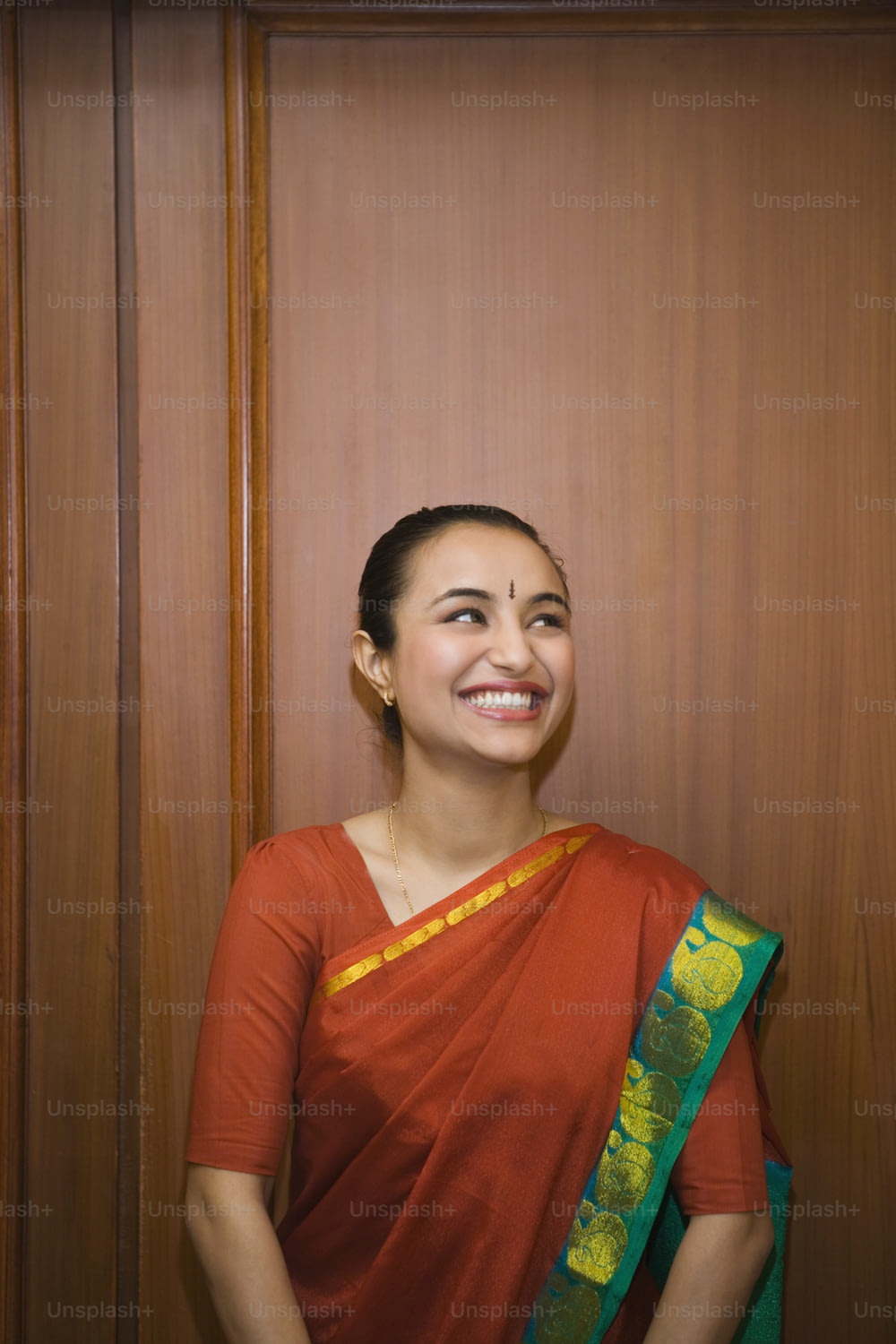 a woman in a red sari smiles for the camera