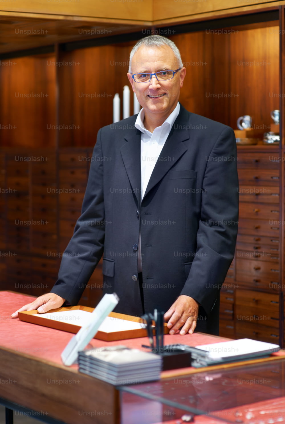 Un uomo in giacca e cravatta in piedi a una scrivania