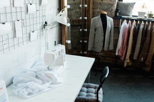 Teil der zeitgenössischen Werkstatt des Modedesigners mit Schläger und Spiegel an der Ecke und elektrischer Nähmaschine auf dem Schreibtisch