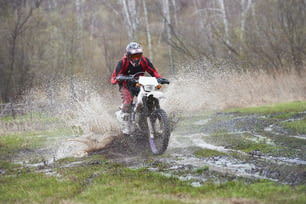 Motorcross rider racing in mud track during outdoor competition