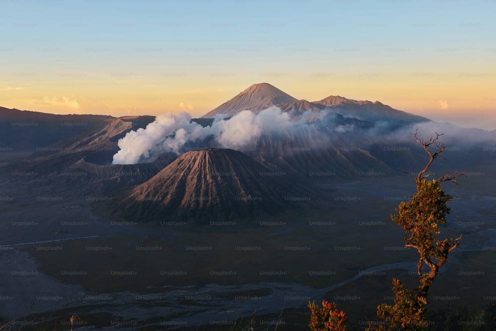 Vulcano attivo in nuvole di fumo con cratere in profondità. Alba dietro il vulcano Mount Gunung Bromo a Giava orientale, Indonesia.