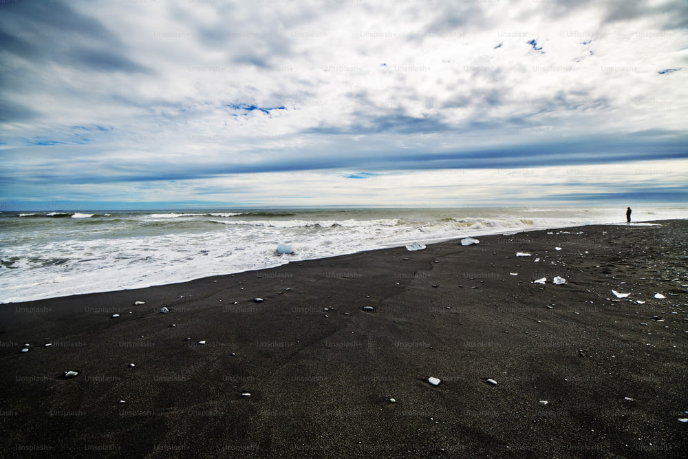 Uma praia de areia preta e paisagem do mar na Islândia, Europa.
