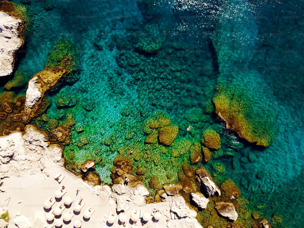 Top view of beach with tourists swimming in beautiful clear sea water.