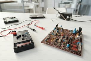 Placa-mãe do computador e dispositivo de transmissão com pinça elétrica no local de trabalho do reparador em laboratório