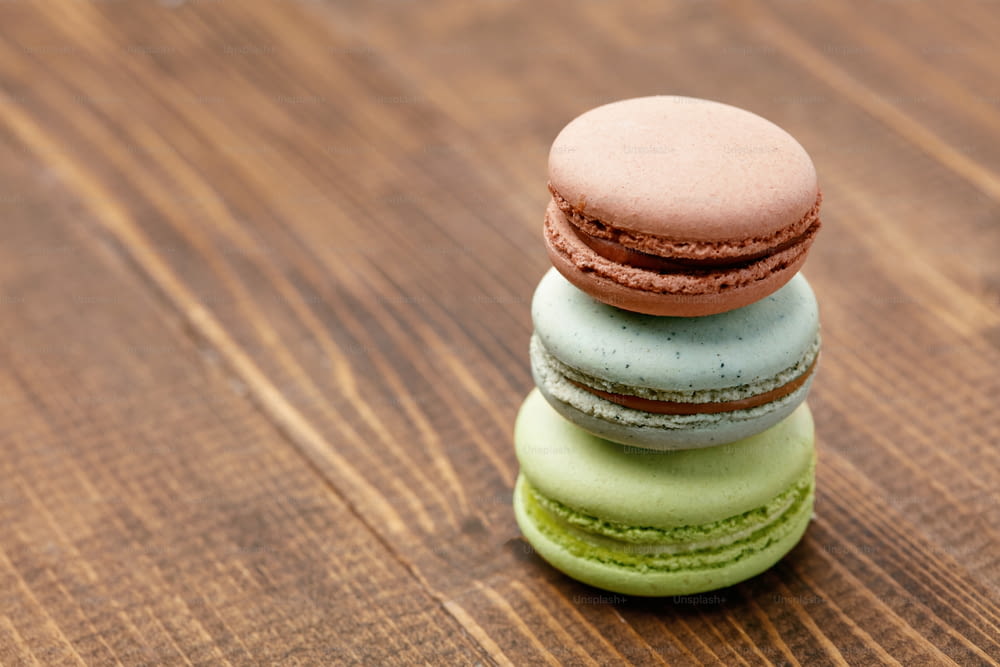 Schokoladen-Macarons auf Holztisch. Nahaufnahme des Stilllebens französischer Makronen. Hohe Auflösung