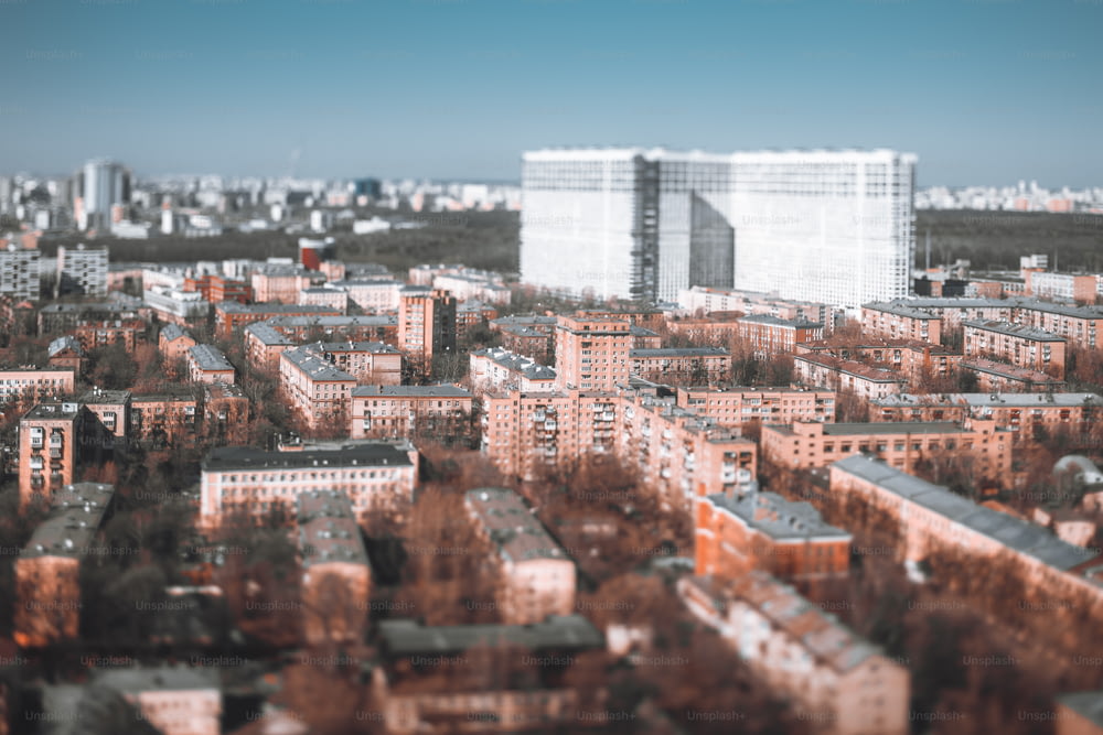 Vero e proprio paesaggio urbano tilt-shift: più blocchi di case di cinque piani, edifici prefabbricati modulari dell'era di Krusciov a Mosca, Russia; grande edificio residenziale a più piani sullo sfondo