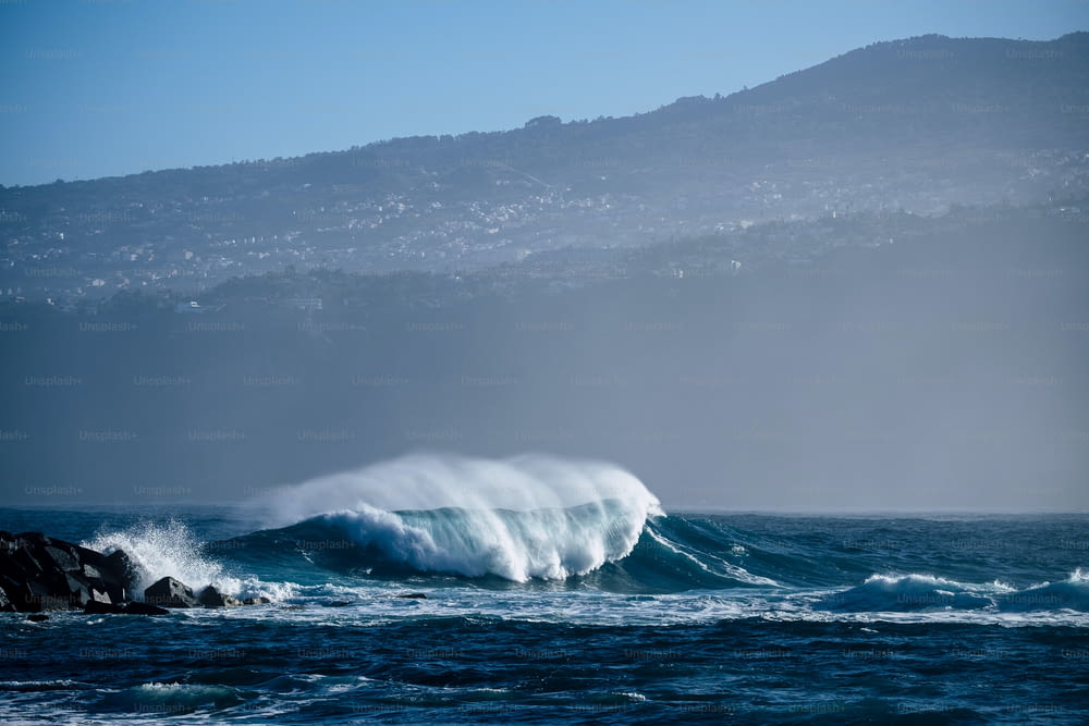 Una sola ola perfecta en el océano azul profundo y peligroso - barril perfecto para surfistas valientes - costa en el fondo para un lugar escénico turístico - disfrute de la belleza del mundo y la sensación del mar
