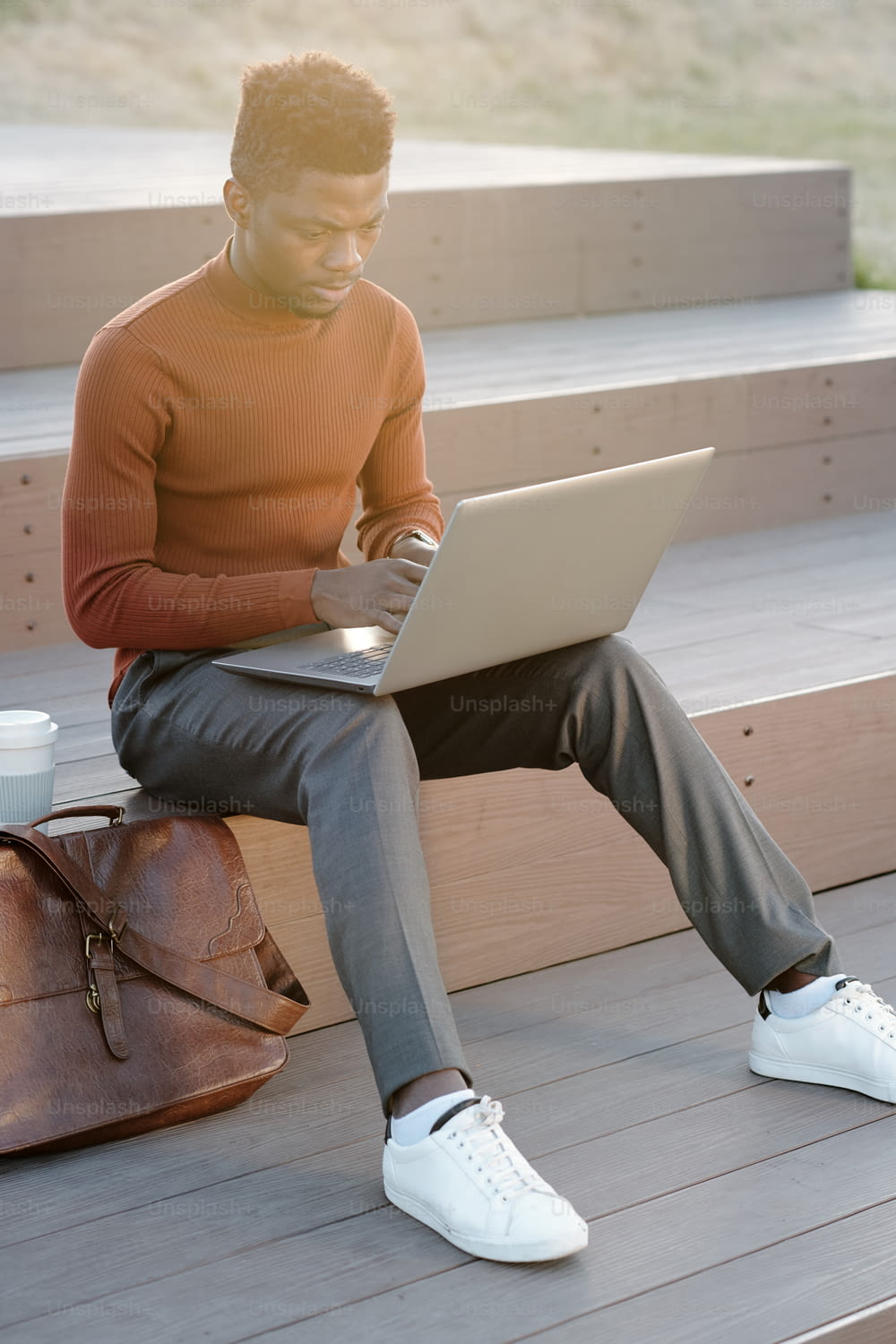 Contemporary African businessman or student with laptop networking outdoors