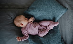 갓 태어난 여자 아기의 상위 뷰, 집에서 실내 소파에 누워 자고 있습니다.