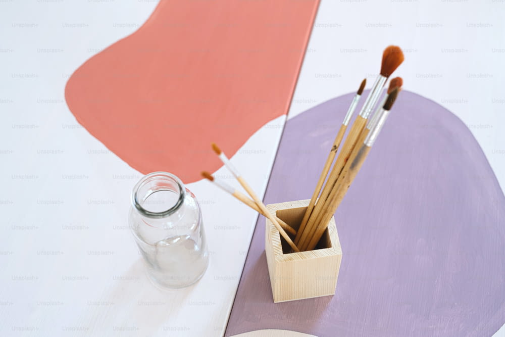 Top view of wooden box container holder with paintbrushes on desk, a natural decor concept.