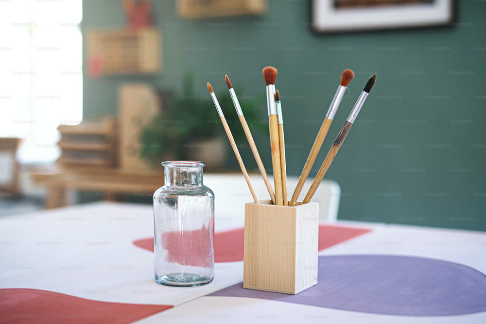 Wooden box container holder with paintbrushes on desk, a natural decor concept.