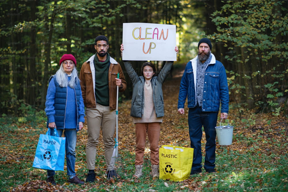 Un grupo diverso de activistas irritados listos para limpiar el bosque, sosteniendo pancartas y mirando a la cámara.