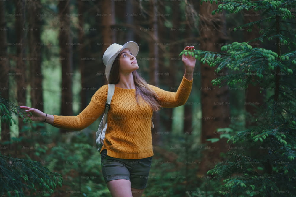 Front view of young woman on a walk outdoors in forest in summer nature, walking.
