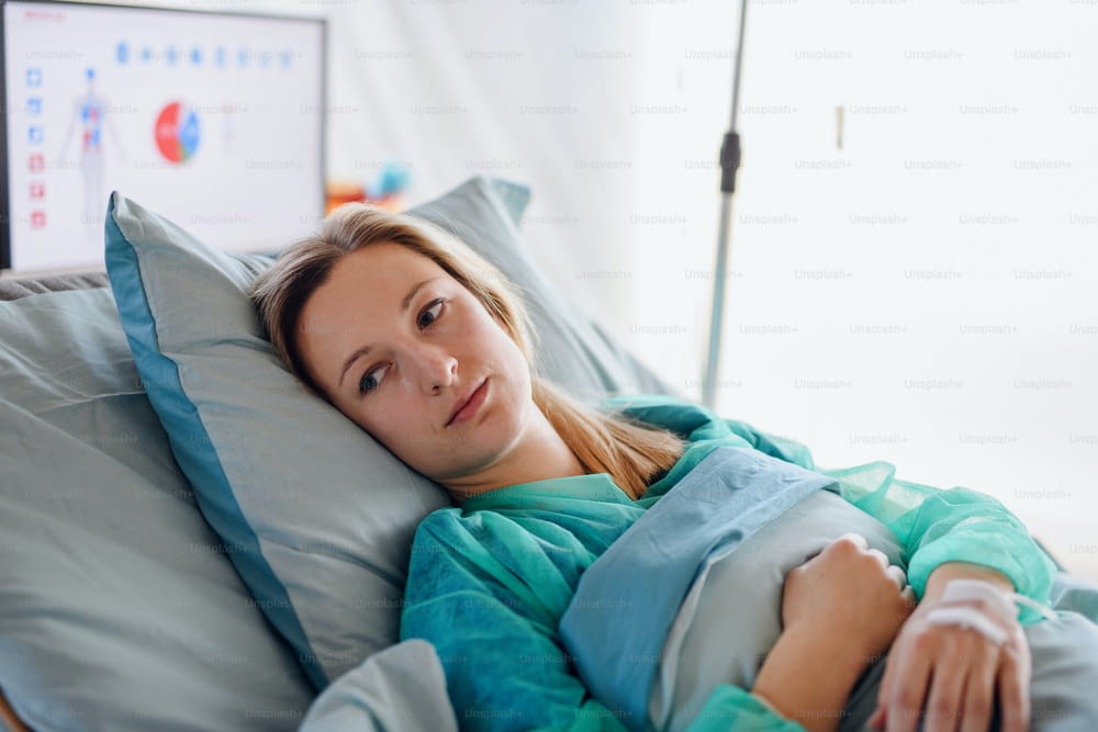 Jeune patient infecté en quarantaine allongé dans son lit à l’hôpital, concept de coronavirus.