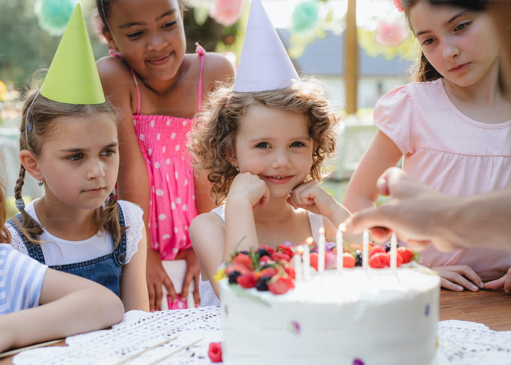 Kids birthday party outdoors in garden in summer, a celebration concept.