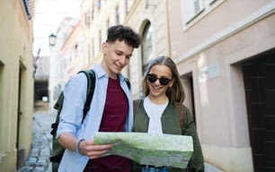 Young couple travelers walking with map in city on holiday, sightseeing.