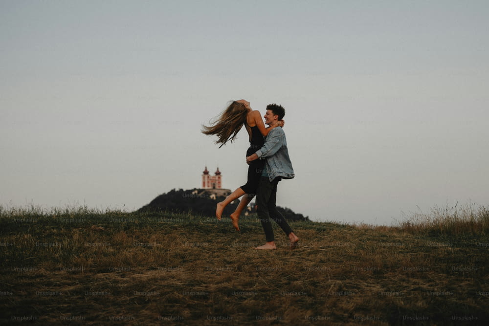 Vue latérale d’un jeune couple lors d’une promenade dans la nature au crépuscule à la campagne, s’amusant à s’étreindre.