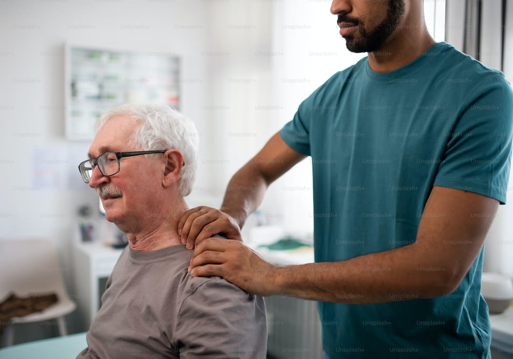 A young physiotherapist massaging the neck of senior patient in a physic room