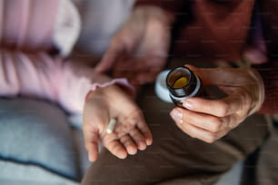 Eine Nahaufnahme von Grnadmothers Hand, die ihrem Enkelkind Medizin gibt.
