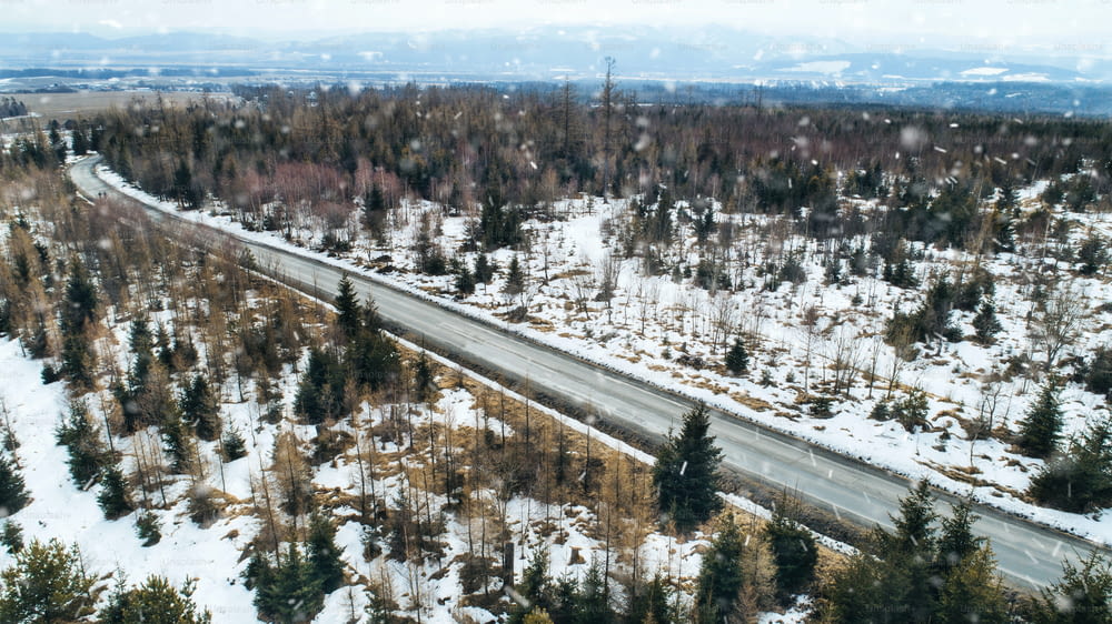 Vue aérienne de la route et des conifères dans la forêt en hiver nature.