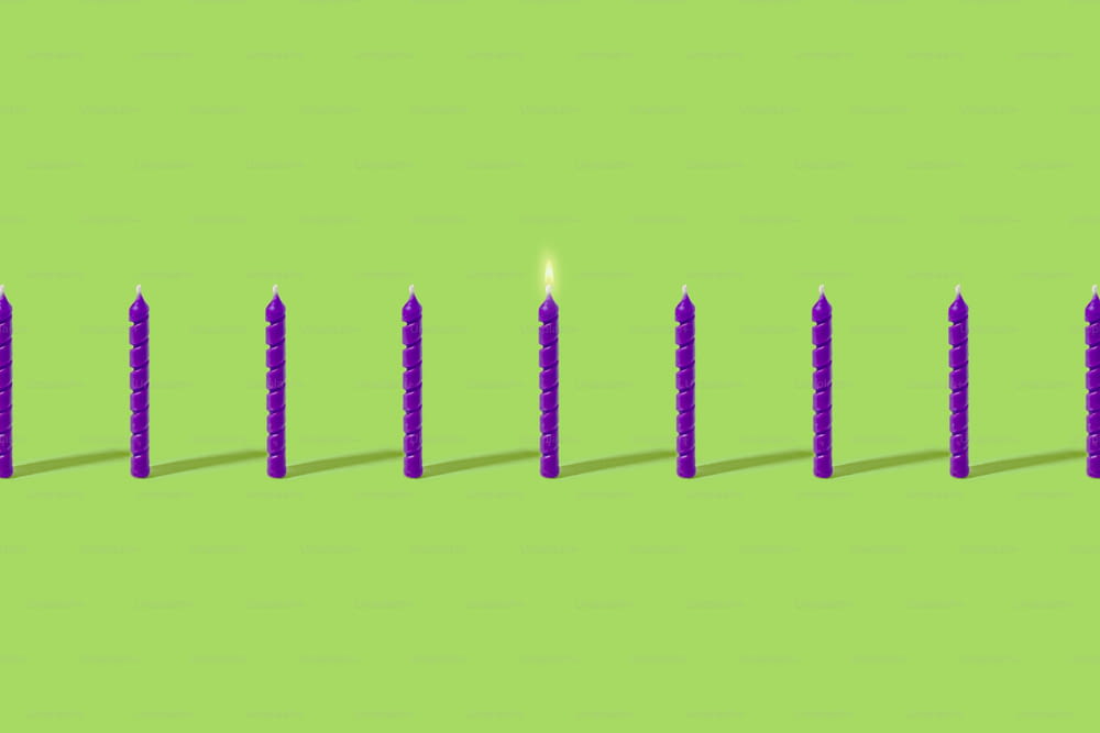 una fila di candele sedute in cima a una superficie verde
