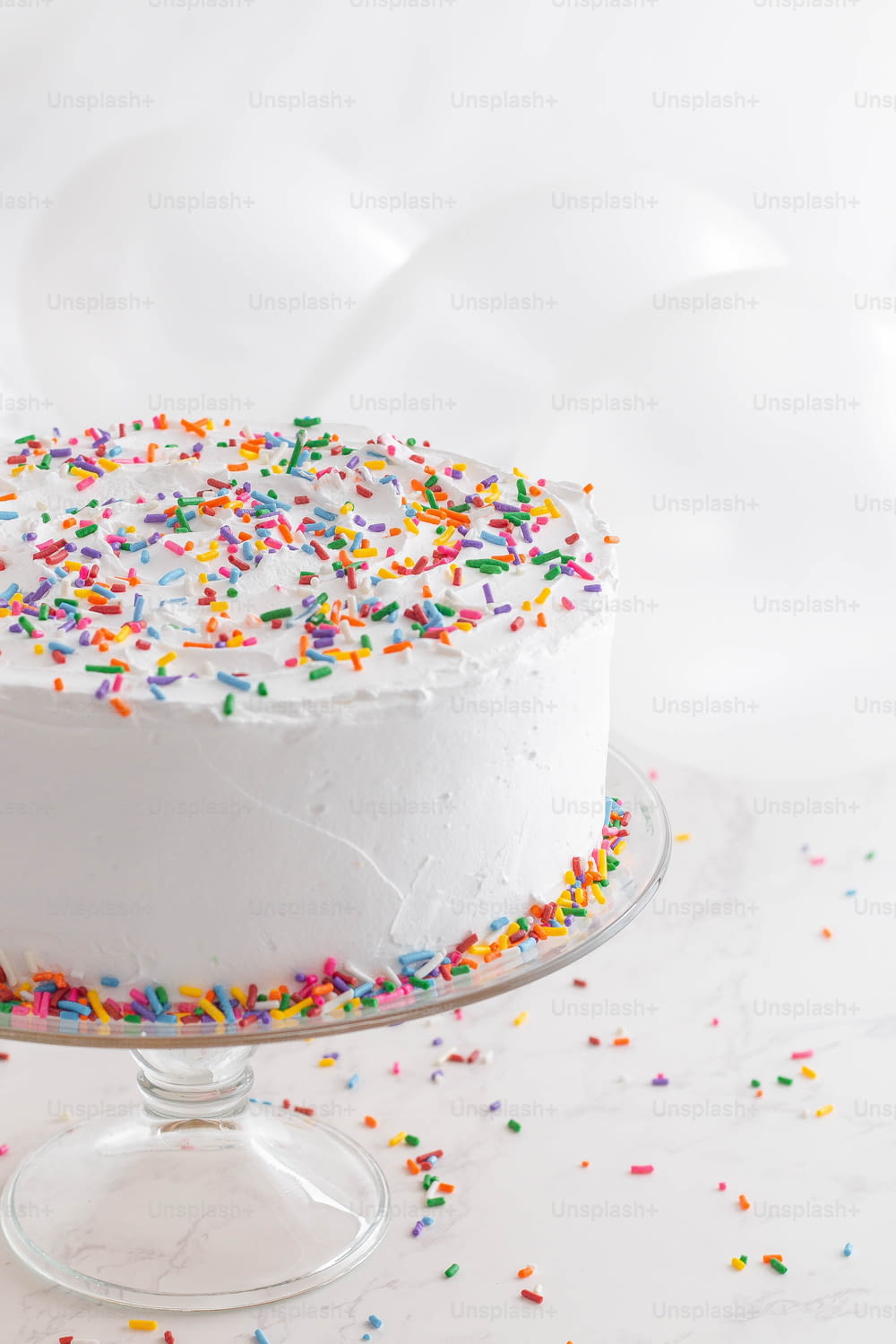 a white cake with sprinkles on a cake plate