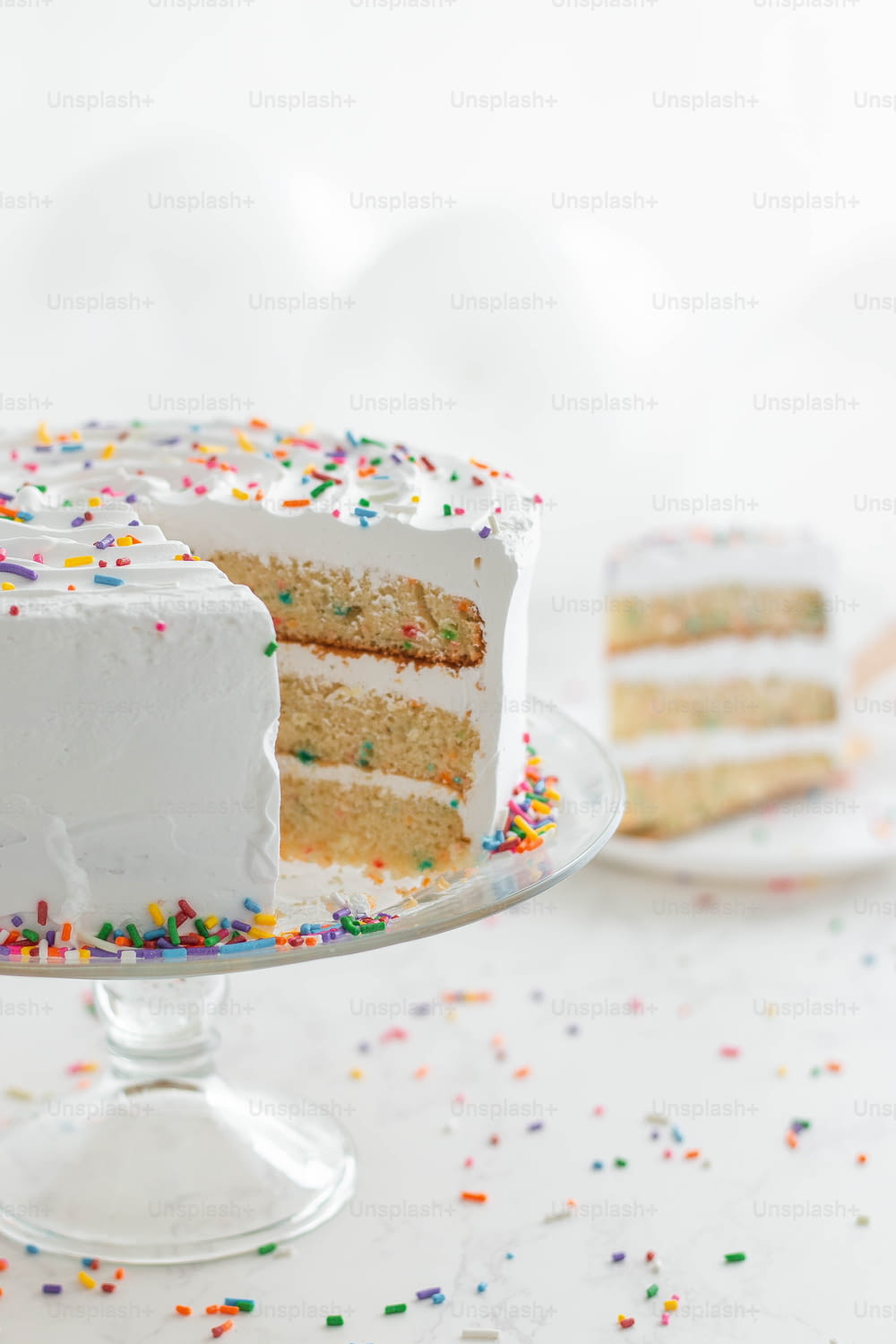 a white cake with white frosting and sprinkles