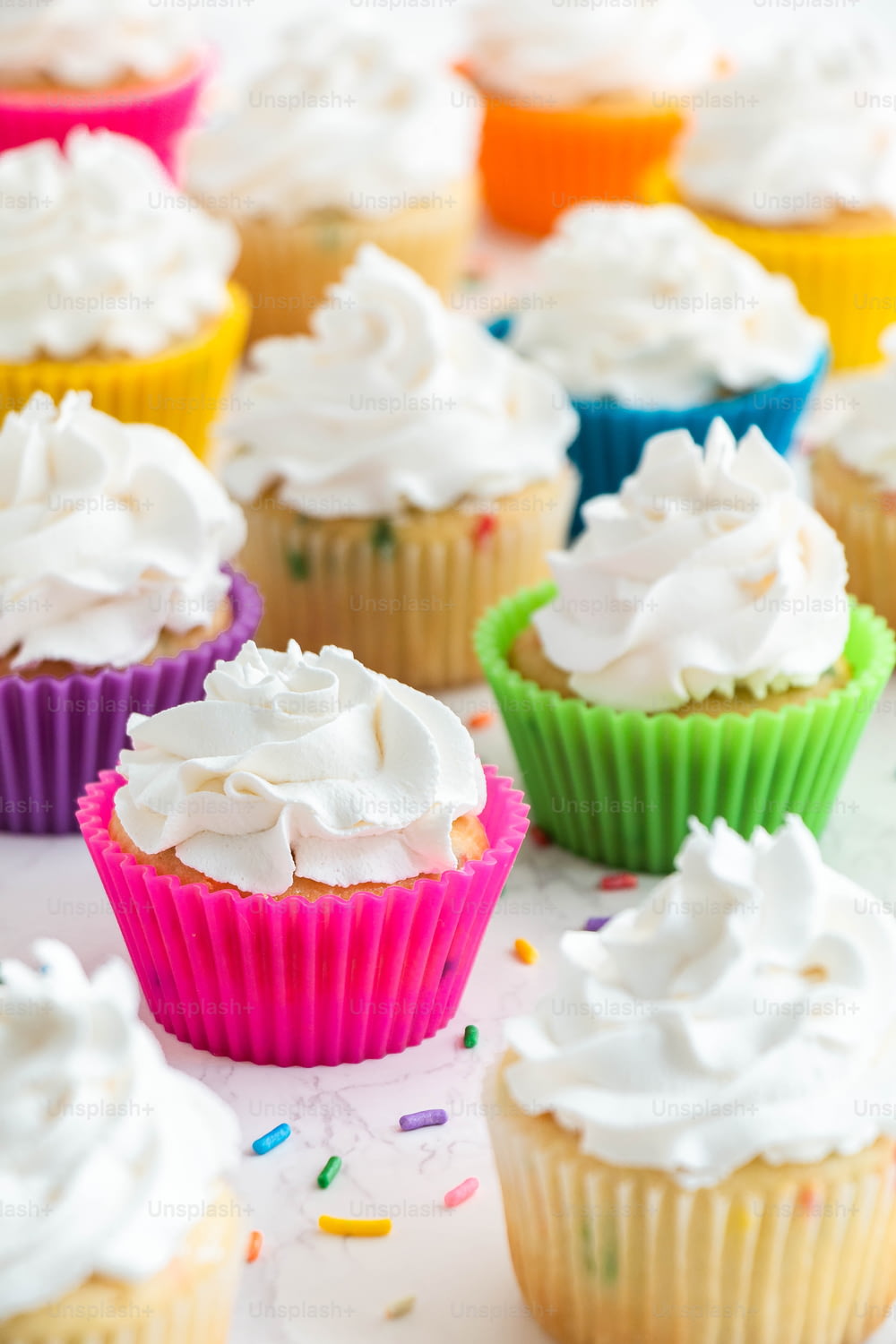 cupcakes con glassa bianca e codette su un tavolo