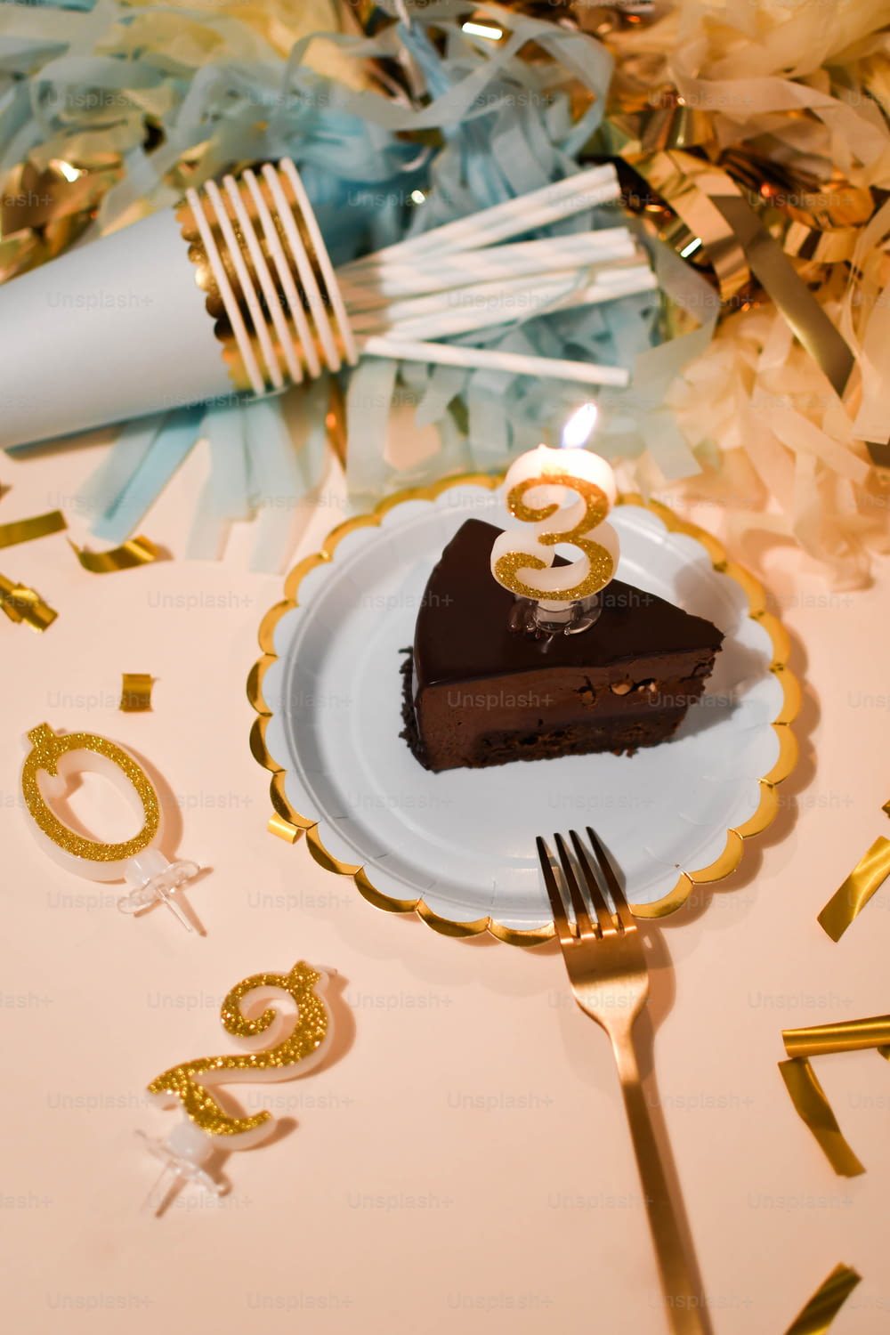 a piece of chocolate cake on a plate with a candle