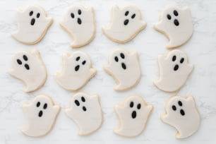 Un tas de biscuits qui ont été décorés pour ressembler à des visages fantômes