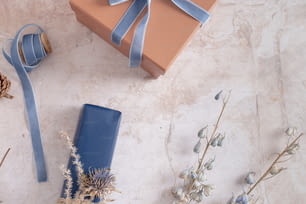 una confezione regalo con un nastro blu e alcuni fiori secchi