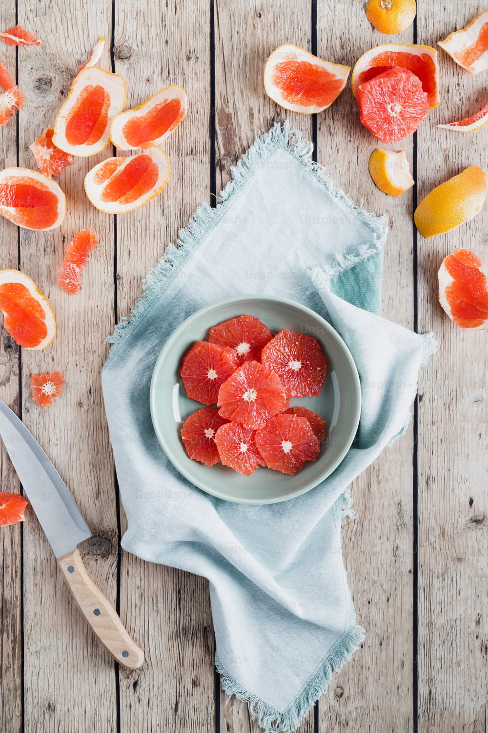 a plate of sliced grapefruits on a table