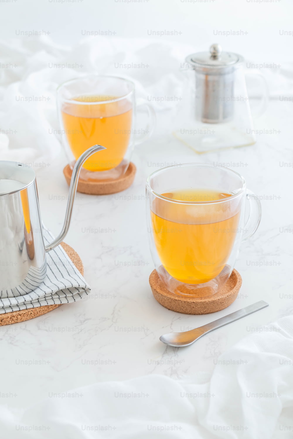 due tazze di tè su un tavolo con un colino da tè