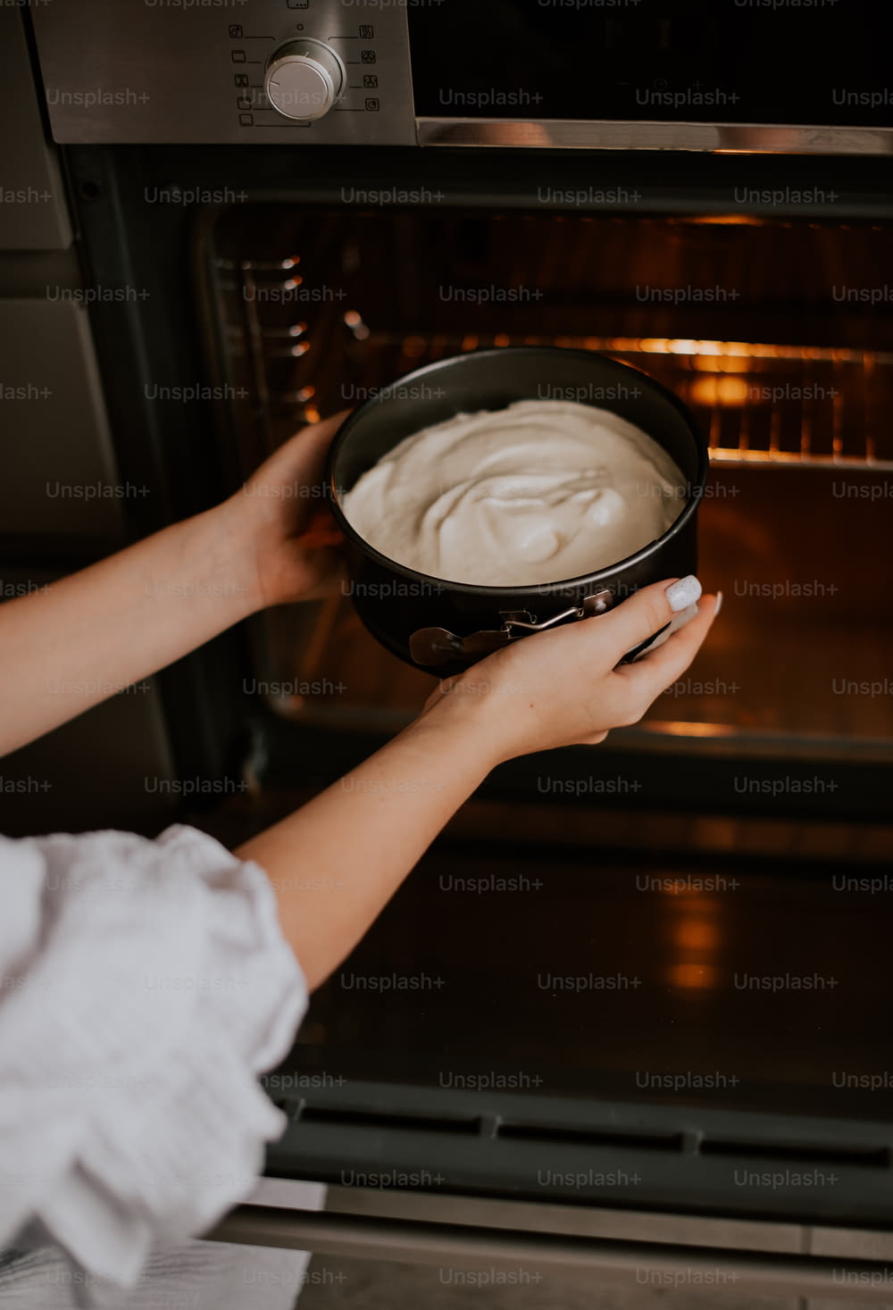 uma pessoa segurando uma panela de comida na frente de um forno