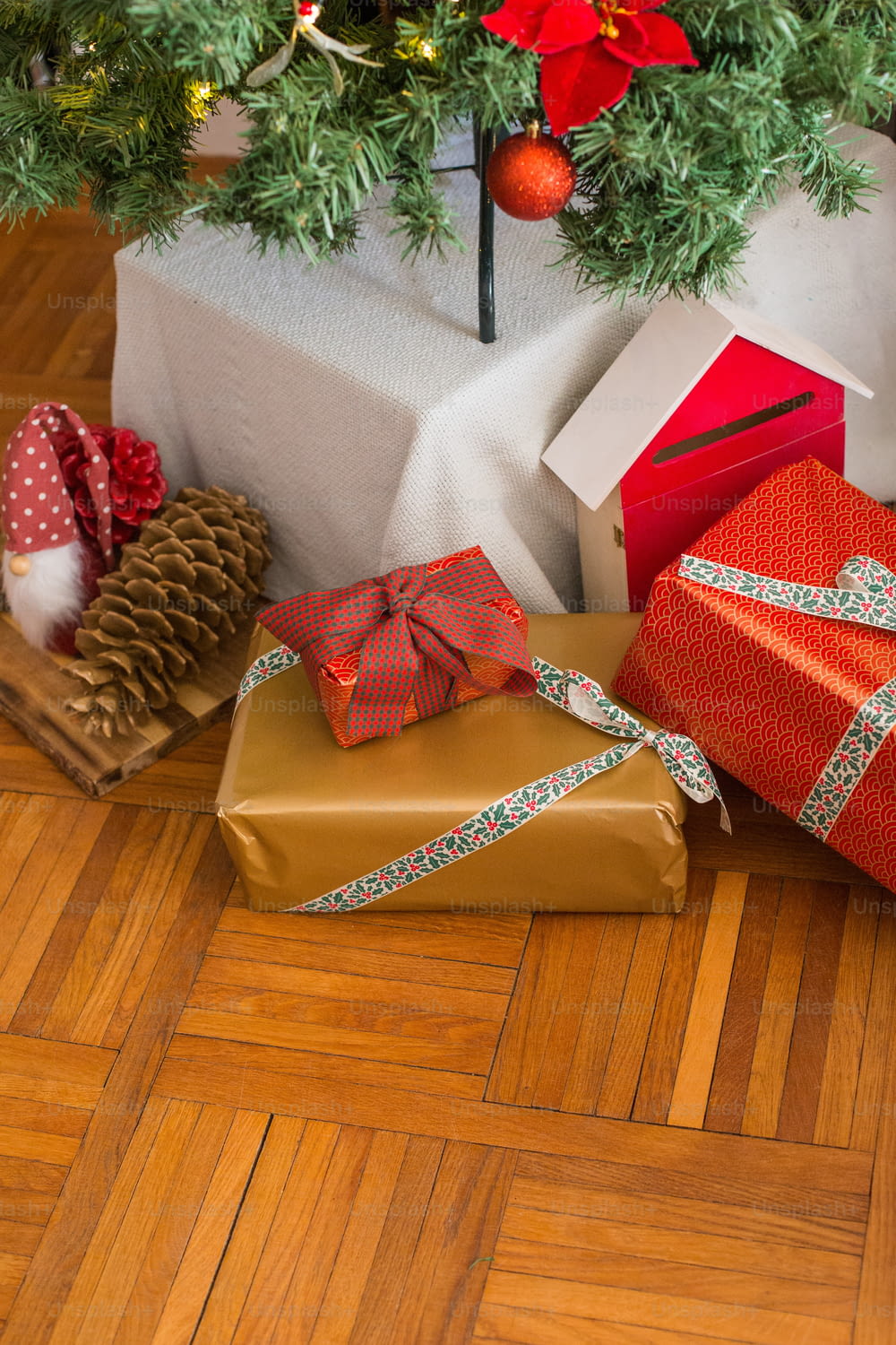 presents under a christmas tree on a wooden floor
