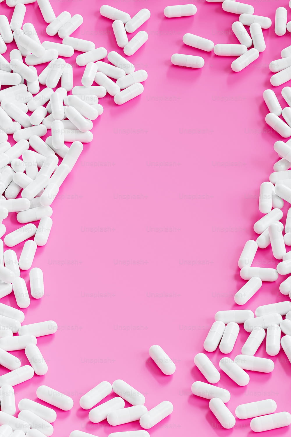 a pink background with white pills on it