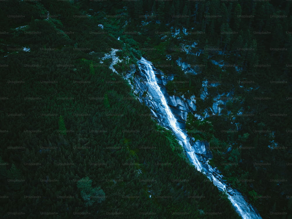an aerial view of a waterfall in a forest