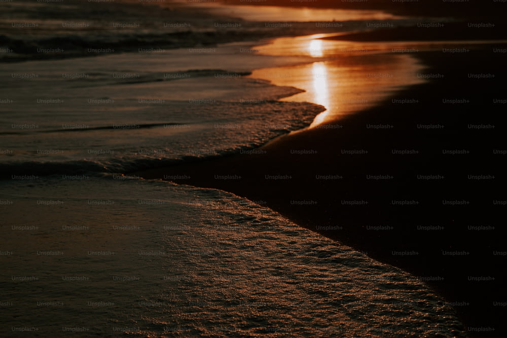 Le soleil se couche sur l’eau à la plage