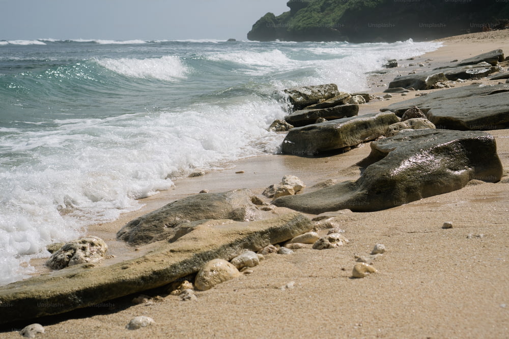 a rocky beach with waves crashing on the shore