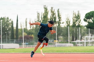 Stock photo of young athlete training with leg prosthesis in running track.