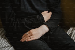 eine Person, die mit der Hand auf der Brust auf einer Couch sitzt