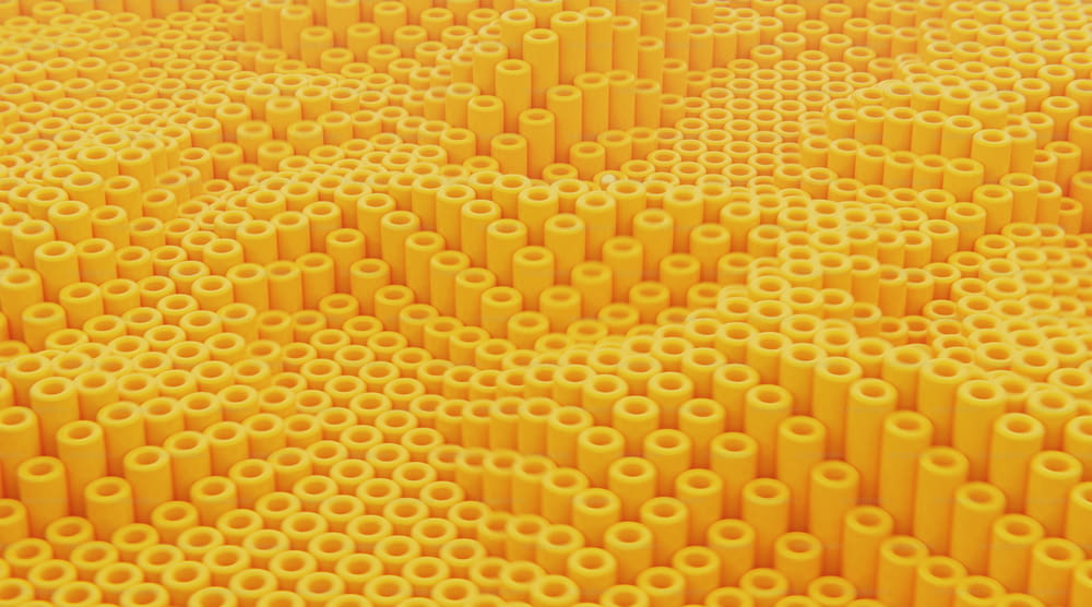 uma grande quantidade de tubos amarelos são dispostos em um padrão