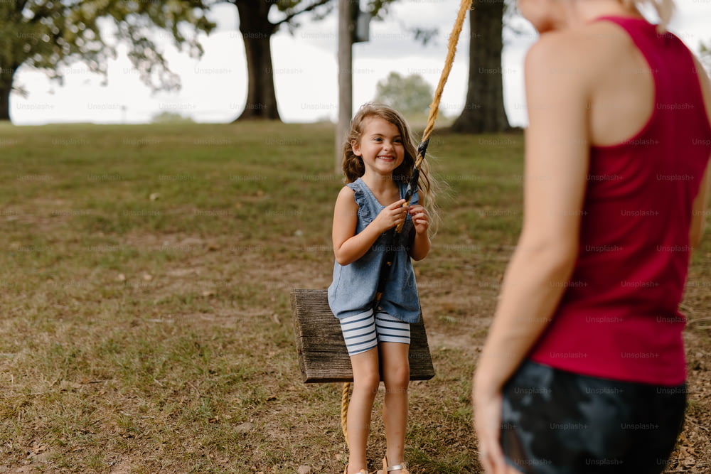 a little girl holding a baseball bat in a field