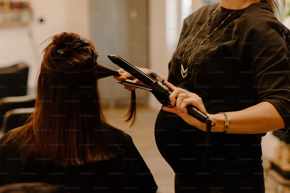 uma mulher está secando o cabelo em um salão
