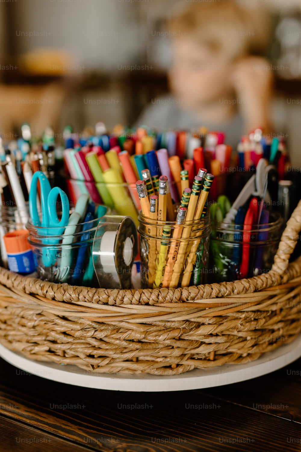 uma cesta cheia de canetas e tesouras de cores diferentes